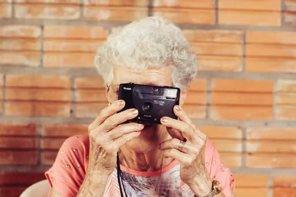 An old woman holding a film camera