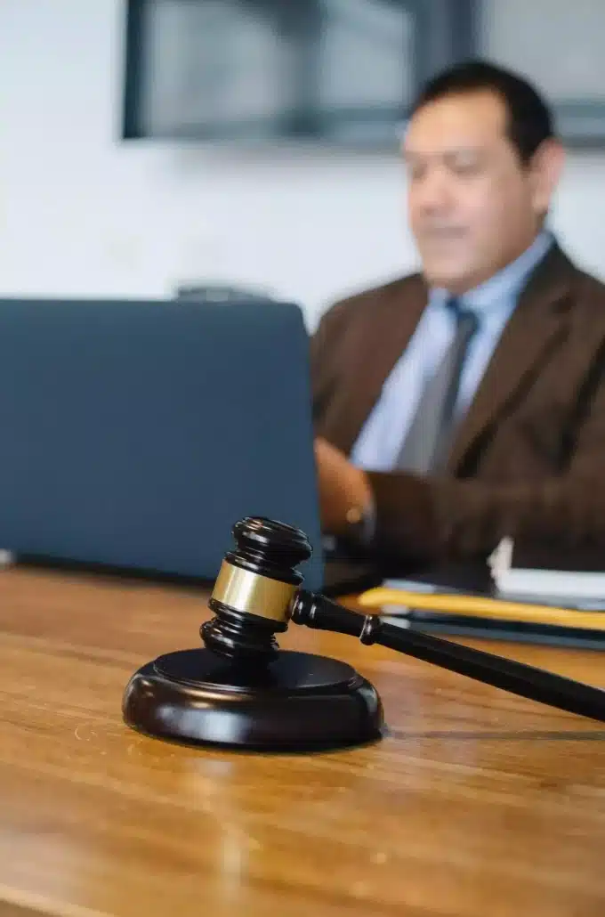 An attorney using a laptop and a wooden gavel