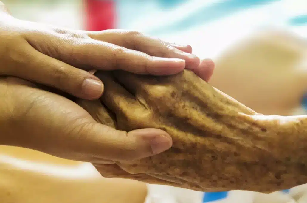 Holding the hand of a senior person.