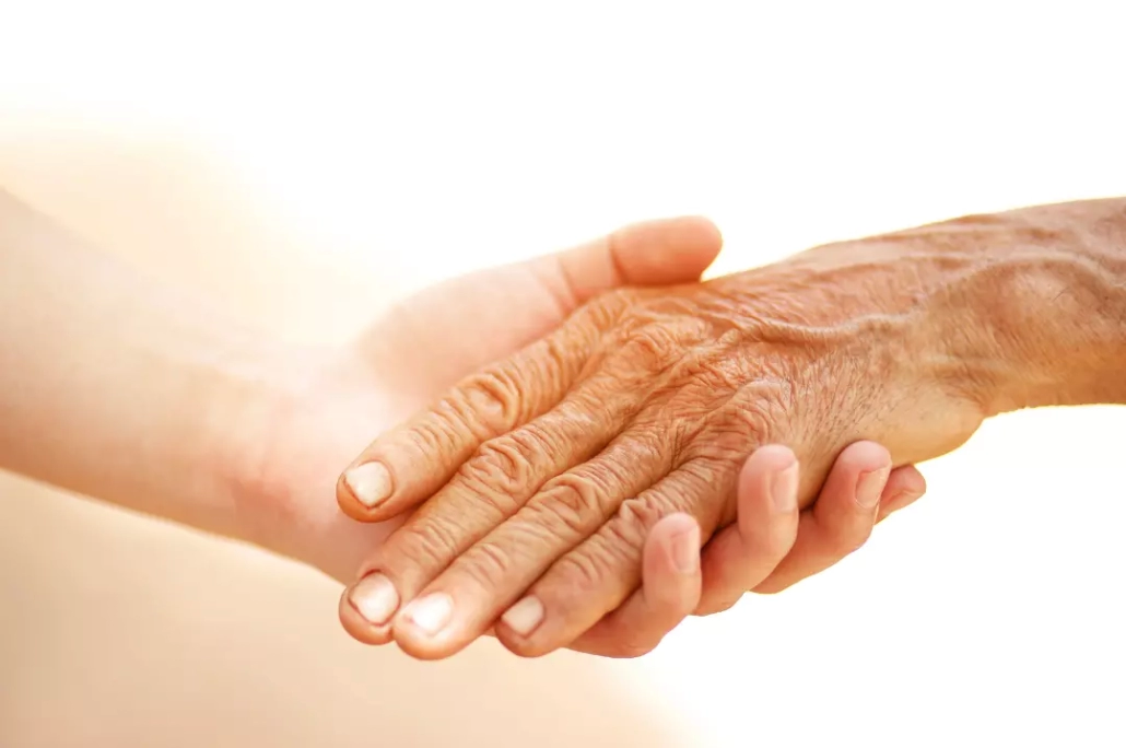 Carer holding an old person's hand.