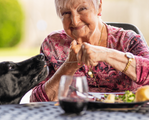 Old woman feeding her dog.
