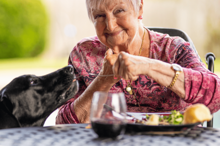 Old woman feeding her dog.