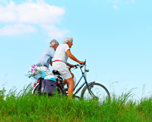 Senior couple promoting healthy ageing by biking together.