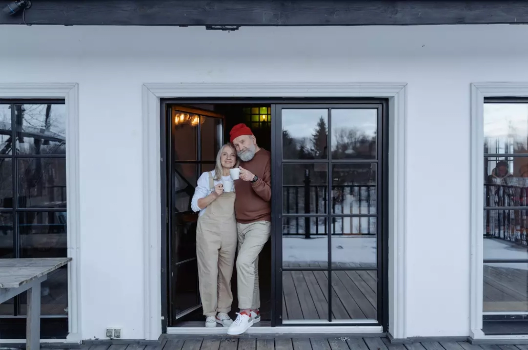 Senior couple standing by the door.