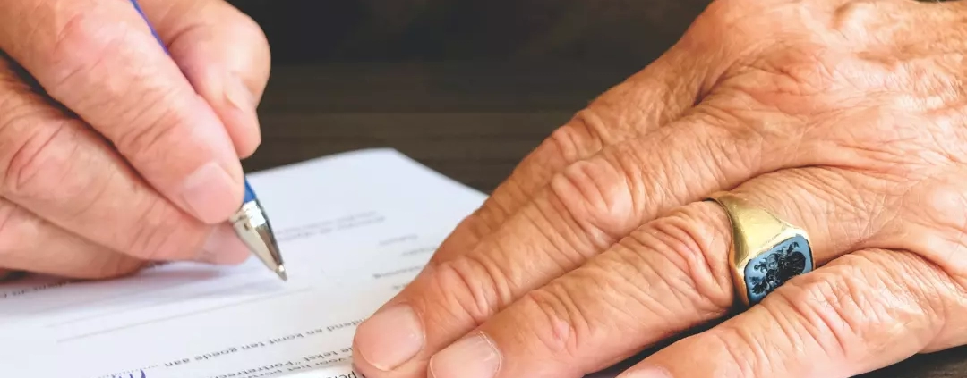 Old person signing a document.