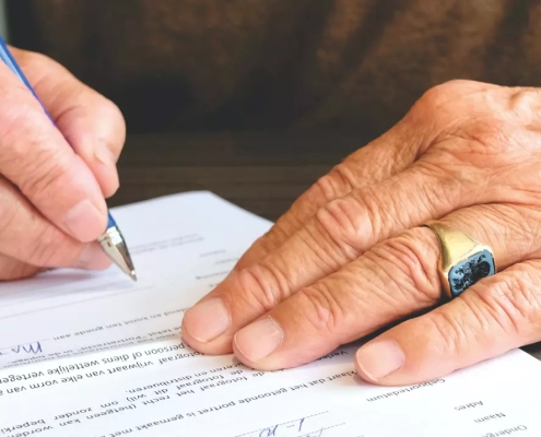 Old person signing a document.