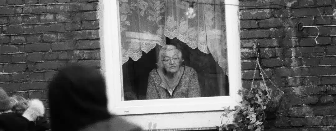 Old woman looking through the window.
