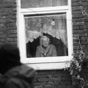 Old woman looking through the window.
