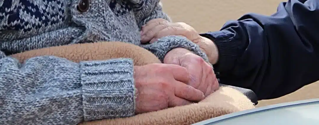 Holding the hands of an elderly.