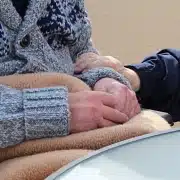 Holding the hands of an elderly.