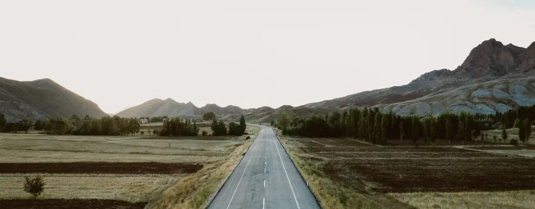 A person standing alone in the middle of the concrete road.