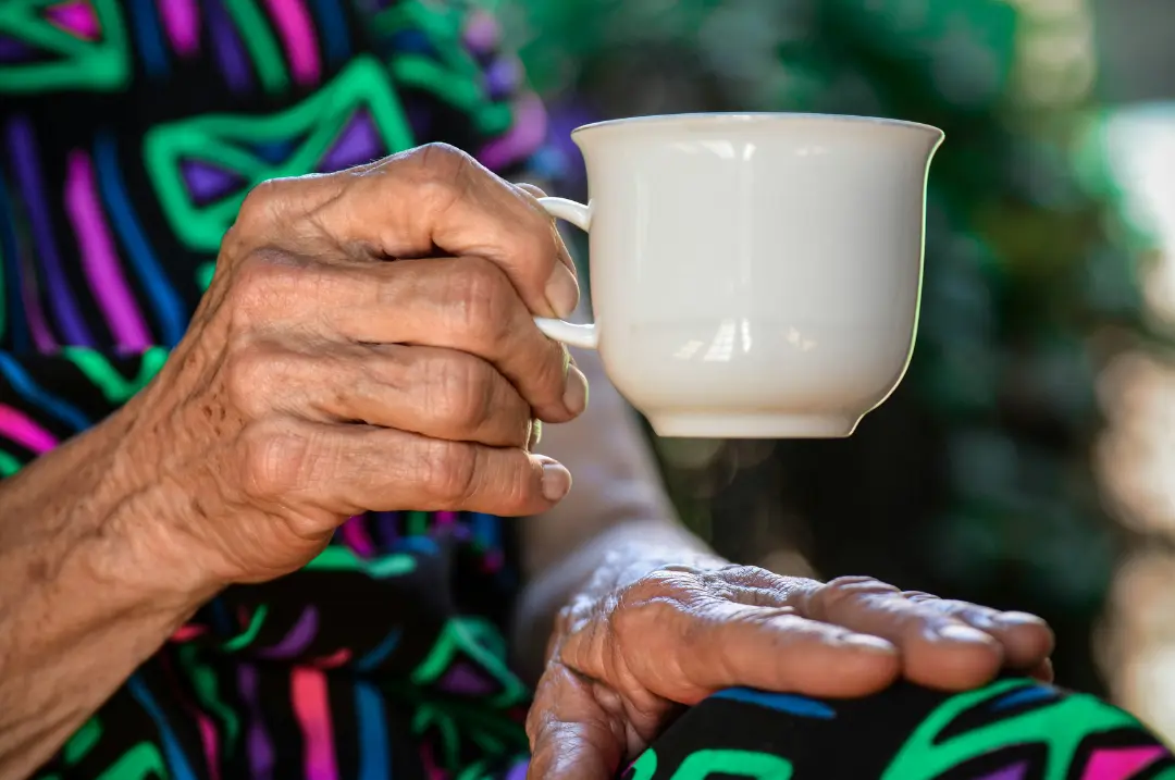 An old woman holding a cup.