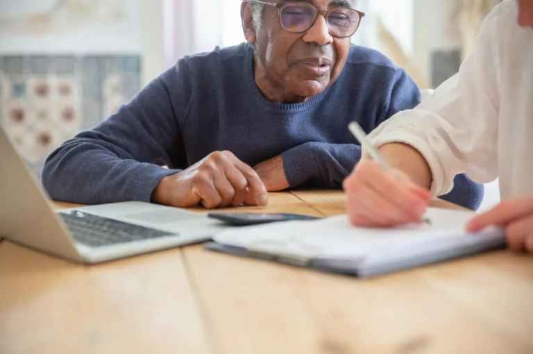 Old man in blue sweater wearing eyeglass.
